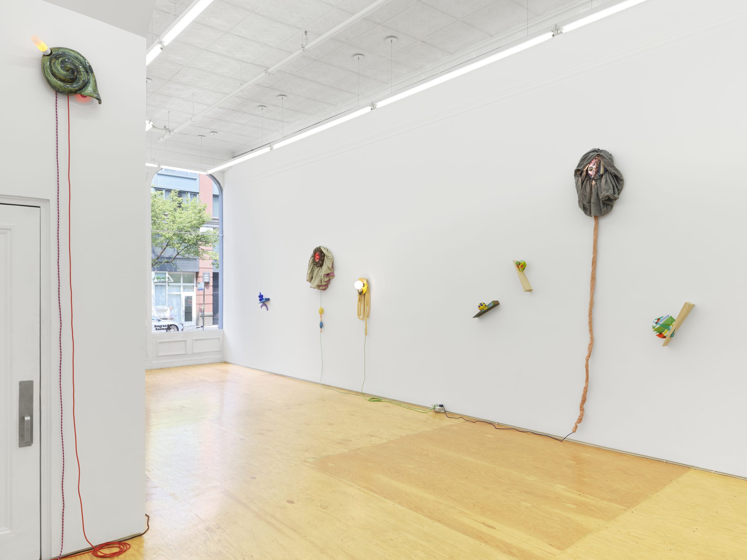Installation view, Laura Aldridge at Margot Samel. Lamps and sculptures playful colors and range of materials, fabric, glass, wood, ceramic, stone.
