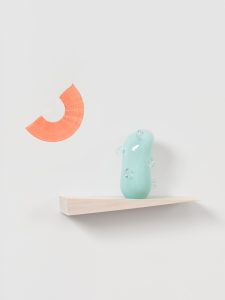 Green ceramic glazed cactus like shape with a semicircle of orange paint