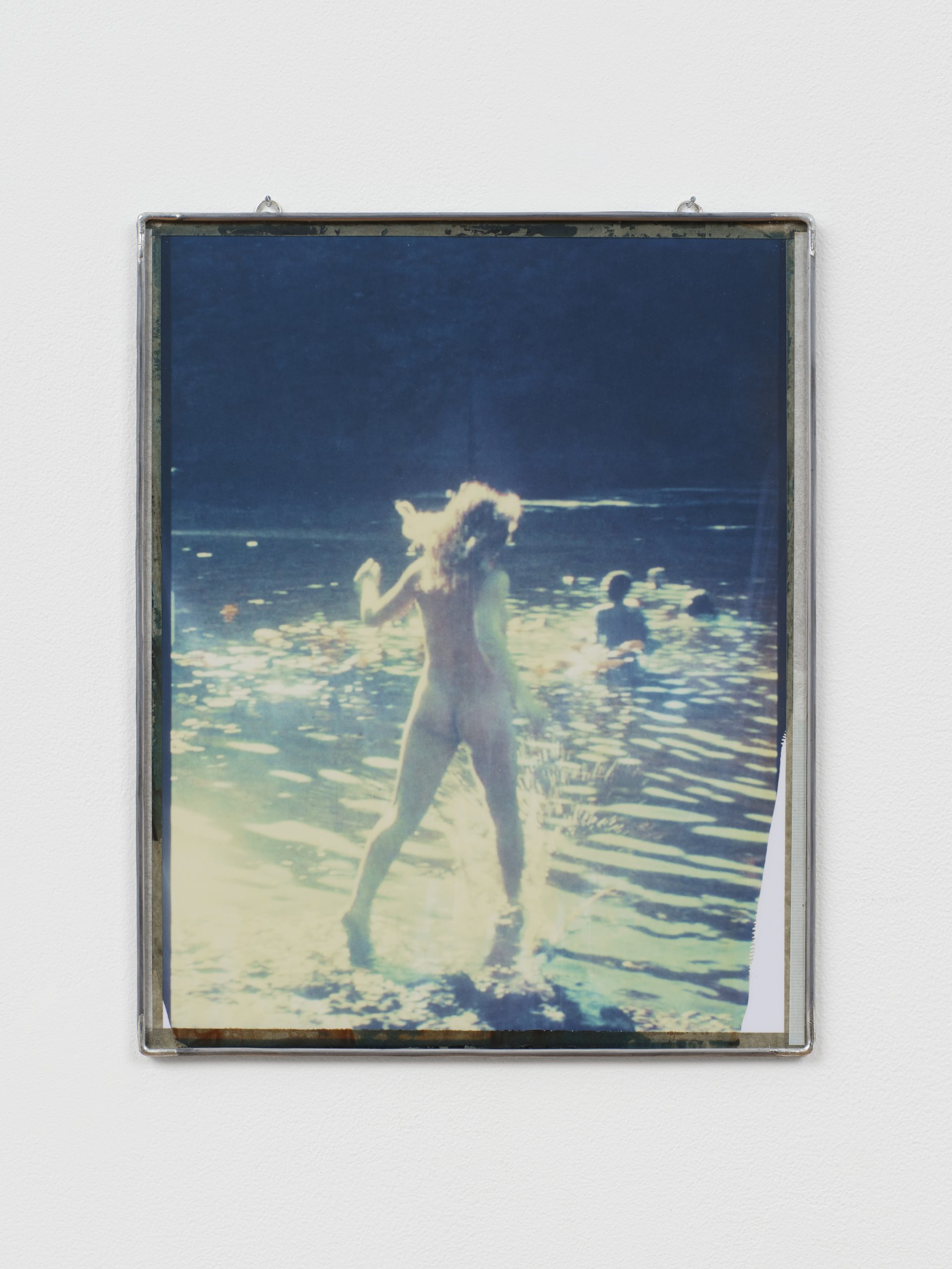 Photograph of a woman jumping into a lake, framed in metal