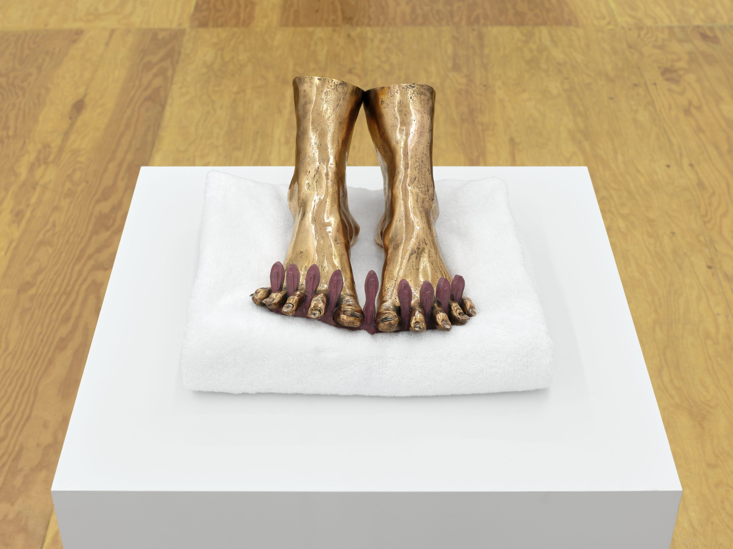 Sculpture of feet in Cast bronze with porcelain and ceramic decals (on-glaze) nails by Man Yau. Displayed on white folded towel in a white pedestal.