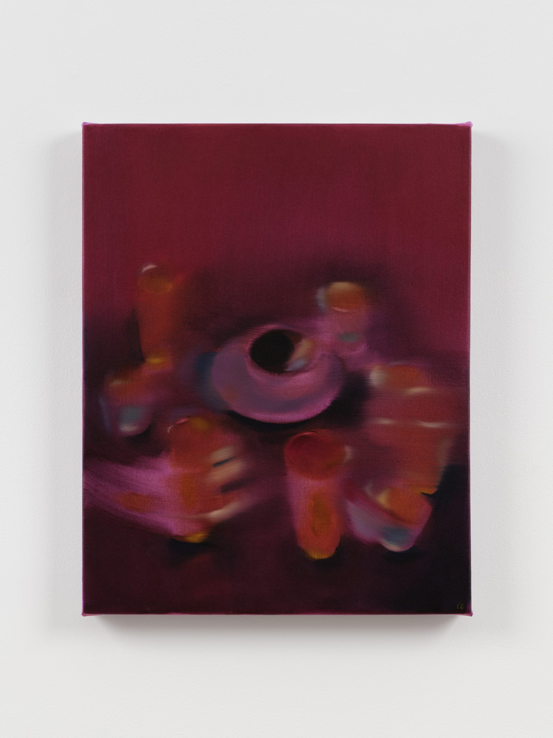 Blurred, magenta-toned still life of glowing cups encircling a dark, circular center.